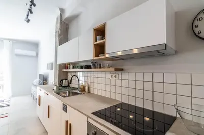 a kitchen with white appliances and a clock on the wall at ARIS Central Athens in Athens