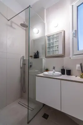 a white bathroom with a sink and a shower at ARIS Central Athens in Athens
