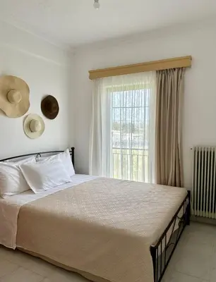 a bedroom with a large bed and a window at Only Sun in Papangeláki