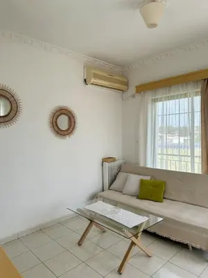 a living room with a couch and a glass table at Only Sun in Papangeláki