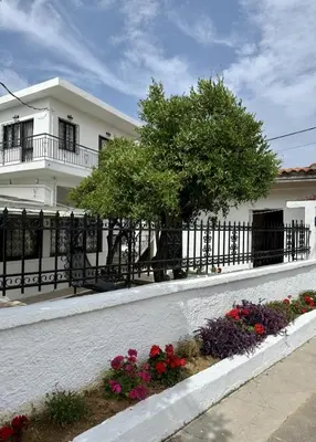 a white house with a fence and flowers at Only Sun in Papangeláki