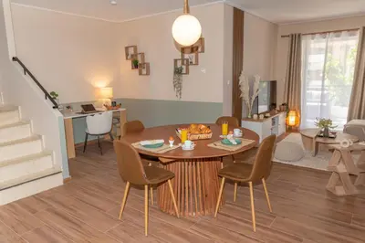 a dining room and living room with a table and chairs at Athena Cocooning Apartment in Piraeus