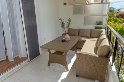 a living room with a couch and a table on a balcony at Athena Cocooning Apartment in Piraeus
