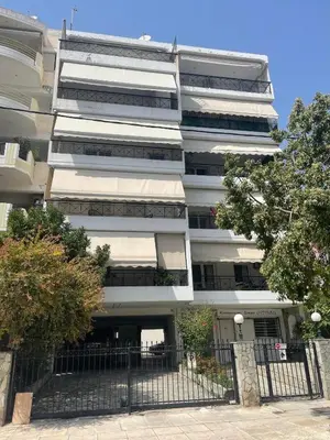 a white building with a fence in front of it at Athena Cocooning Apartment in Piraeus