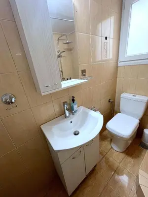 a bathroom with a white sink and a toilet at MediTerra Stay Athens Riviera in Athens