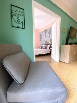 a living room with a couch and a bedroom at MediTerra Stay Athens Riviera in Athens