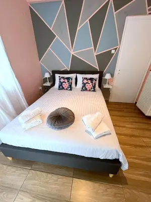 a bedroom with a bed with a large headboard at MediTerra Stay Athens Riviera in Athens