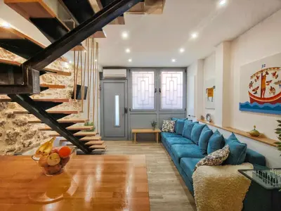 a living room with a blue couch and a staircase at Athens Vibe in Historic Center in Athens