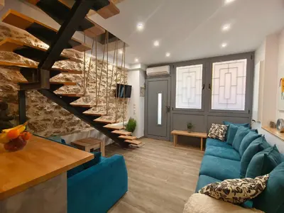 a living room with a blue couch and a staircase at Athens Vibe in Historic Center in Athens