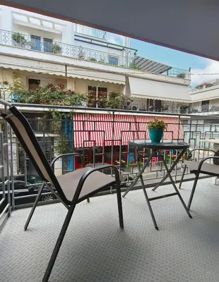 a chair sitting on a balcony with a table at Athens Vibe in Historic Center in Athens