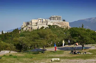 a group of people sitting on a hill with a castle at Athens Vibe in Historic Center in Athens
