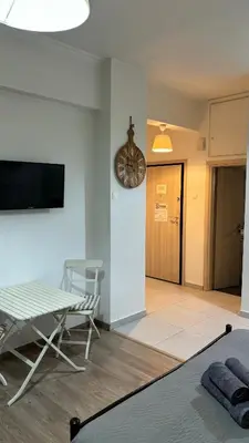 a living room with a table and a clock on the wall at Apartment in Athens centre in Athens