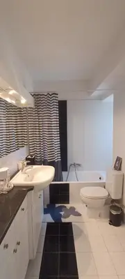 a bathroom with a sink and a toilet and a tub at Cozy Room with Sea View in Athens