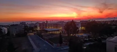 a view of a city at sunset at Cozy Room with Sea View in Athens