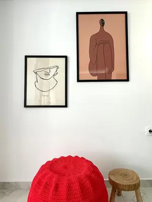 two framed drawings of a mannequin on a wall with a red hat at Walk into Dream of Acropolis 10 in Athens