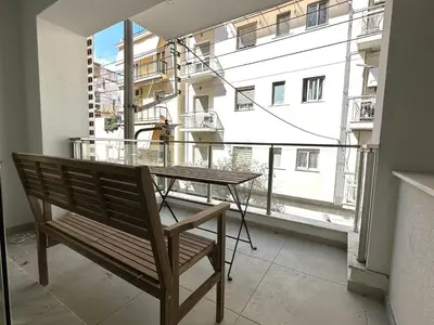 a bench sitting in front of a balcony with a table at Walk into Dream of Acropolis 10 in Athens
