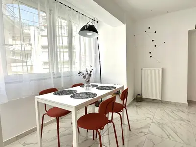 a dining room with a white table and chairs at Walk into Dream of Acropolis 10 in Athens