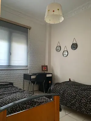 a bedroom with two beds and a desk and a window at Apostolis Apartment, Argyroupoli, Athens in Athens