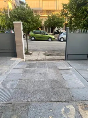 a street with cars parked on the side of a road at Apostolis Apartment, Argyroupoli, Athens in Athens