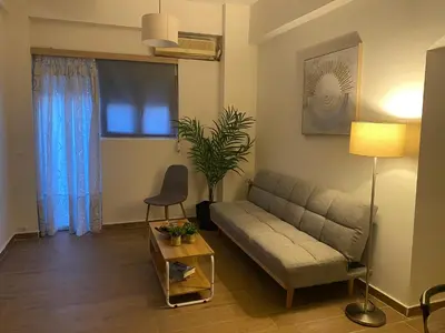 a living room with a couch and a table at Apostolis Apartment, Argyroupoli, Athens in Athens