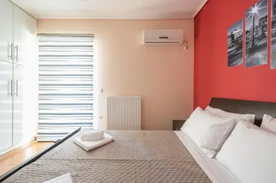 a bedroom with a bed and a red wall at Rigas apartment in Ilioupoli Athens in Athens