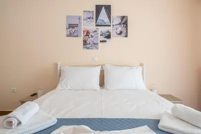 a bedroom with a white bed with towels on it at Rigas apartment in Ilioupoli Athens in Athens
