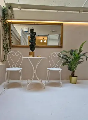two white chairs and a table and a mirror at Lindy S in Athens