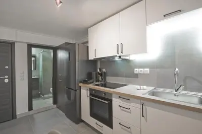 a kitchen with white cabinets and a sink at Studio Stratos ideal for 2-3 night Weekends in Athens