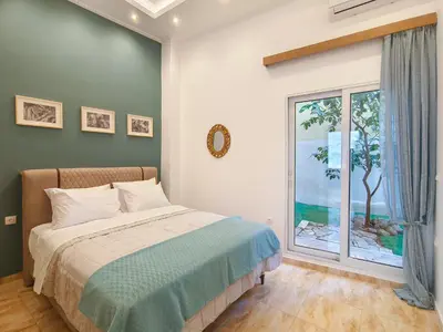 a bedroom with a bed and a large window at Zen Garden, 600m from Acropolis Museum in Athens