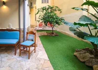 a patio with green grass and a chair and a table at Zen Garden, 600m from Acropolis Museum in Athens