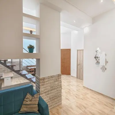 a living room with a blue couch and a staircase at Zen Garden, 600m from Acropolis Museum in Athens