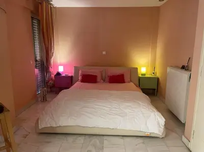 a bedroom with a large white bed with red pillows at Lovely Maisonette & Parking in Athens