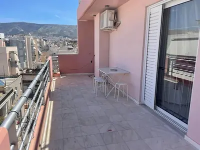 a balcony with a table and a view of a city at Lovely Maisonette & Parking in Athens