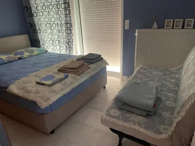 a bedroom with a bed and a chair in it at Lovely Maisonette & Parking in Athens