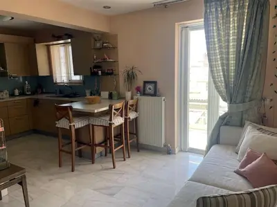 a kitchen and living room with a table and a couch at Lovely Maisonette & Parking in Athens