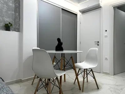 a dining room with a table and two white chairs at Cozy Elegant Apartment #2 VIPGreece in Athens