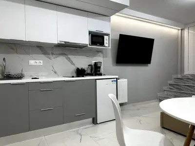 a kitchen with white cabinets and a table and a microwave at Cozy Elegant Apartment #2 VIPGreece in Athens