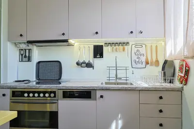 a kitchen with white cabinets and a stove at Faliron Urban Retreat in Athens
