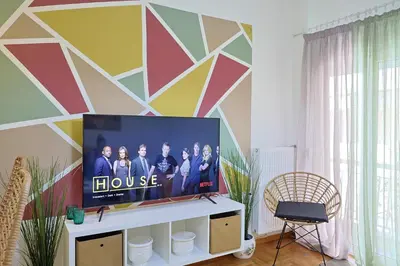 a television in a living room with a colorful wall at Faliron Urban Retreat in Athens