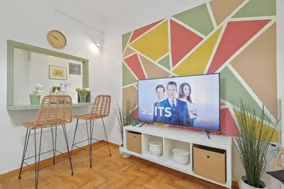 a living room with a tv and two chairs at Faliron Urban Retreat in Athens