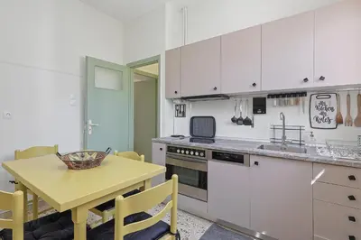 a kitchen with white cabinets and a yellow table at Faliron Urban Retreat in Athens