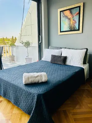 a bedroom with a bed with a blue blanket at Acropolis Compass Residence in Athens