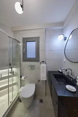 a bathroom with a toilet and a sink and a mirror at Acropolis Compass Residence in Athens