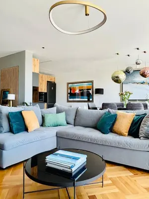 a living room with a blue couch and a glass table at Acropolis Compass Residence in Athens