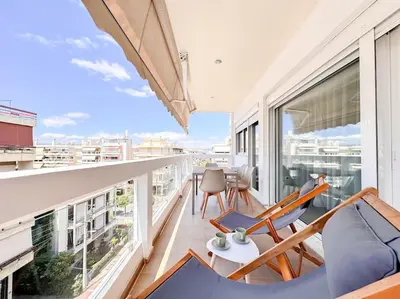 a balcony with a couch and chairs on a building at Pame Rentals - Chic Alimos Home, 5 Min Walk to the Beach in Athens