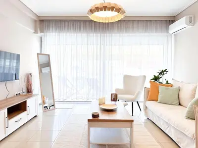 a living room with a couch and a table at Pame Rentals - Chic Alimos Home, 5 Min Walk to the Beach in Athens