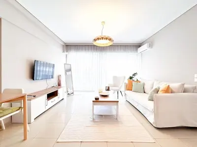 a living room with a white couch and a table at Pame Rentals - Chic Alimos Home, 5 Min Walk to the Beach in Athens
