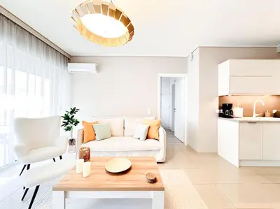 a living room with a white couch and a table at Pame Rentals - Chic Alimos Home, 5 Min Walk to the Beach in Athens