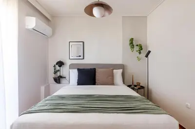 a bedroom with a bed with a green blanket at Modern Escape 2BR Apartment in Glyfada by UPSTREET in Athens