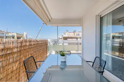 a balcony with a glass table and chairs at Modern Escape 2BR Apartment in Glyfada by UPSTREET in Athens